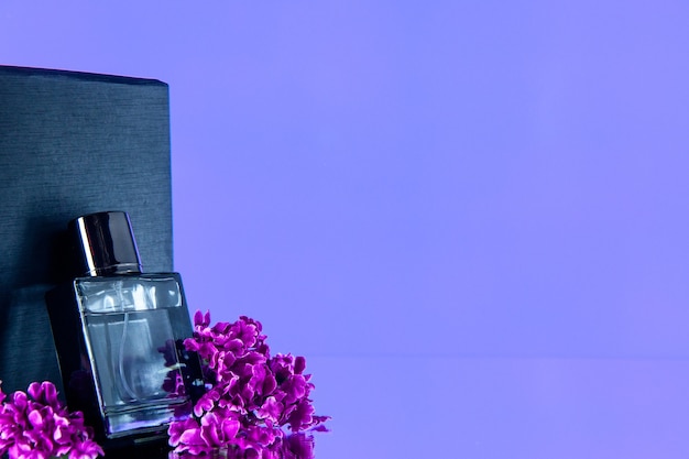 Photo vue de face parfum cher avec des fleurs sur fond violet parfum valentines day sentiment odeur parfum amour cadeau flacon