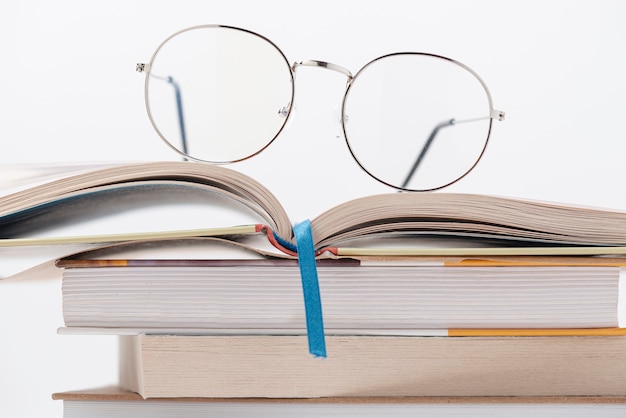 Vue de face pile de livres avec des lunettes sur le dessus