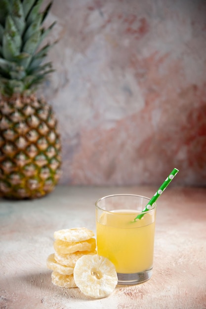 Photo vue de face pipette en verre de jus ananas sec anneaux ananas sur fond beige