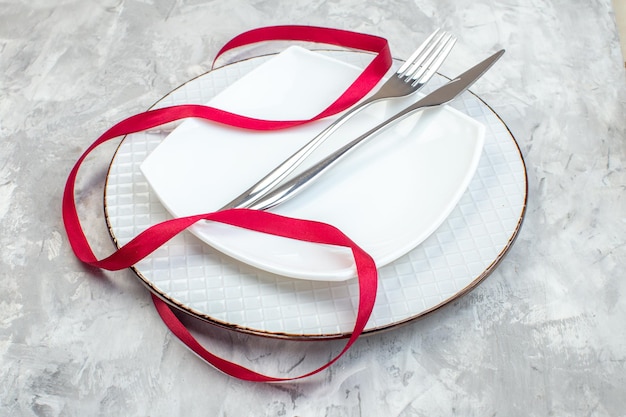 vue de face plaque blanche avec fourchette et couteau sur une surface claire mesdames de cuisine nourriture féminité repas en verre couleur horizontale