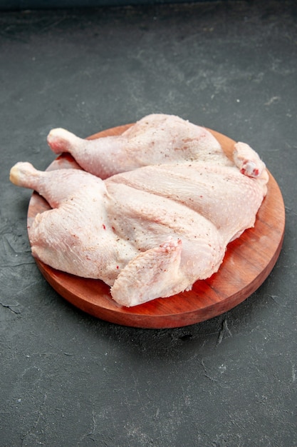 vue de face poulet cru frais sur le fond sombre plat de cuisson nourriture salade barbecue couleur dîner oiseau