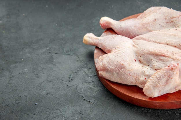 vue de face poulet cru frais sur fond sombre plat de cuisson salade barbecue couleur dîner oiseau