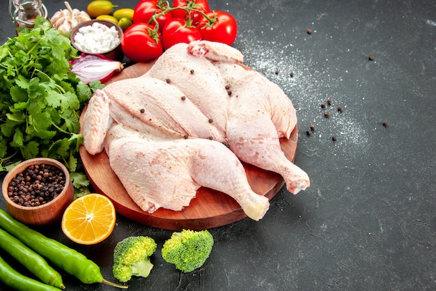 vue de face poulet cru frais avec des tomates vertes et rouges sur fond gris poivre santé plat de cuisson salade nourriture dîner barbecue couleur