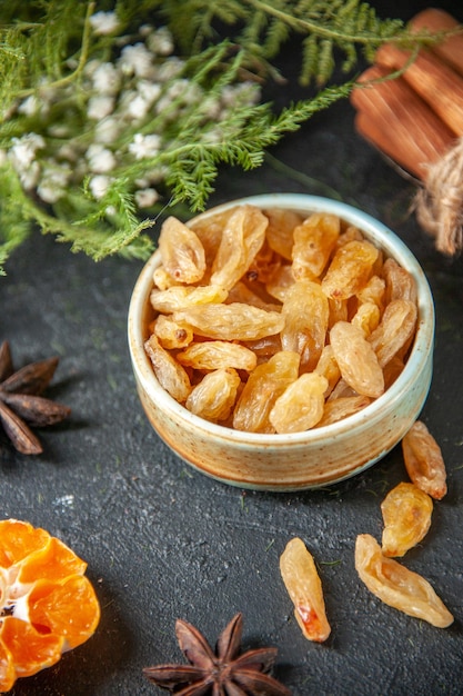 vue de face raisins secs frais à la cannelle sur fond sombre pacanes photo aigre-douce de raisin