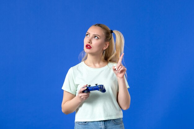 vue de face rêver jeune femme avec manette de jeu sur fond bleu joystick vidéo virtuel jeunesse joueur adulte en ligne joyeux gagnant