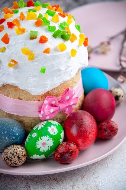 vue de face savoureux gâteau de pâques avec des œufs colorés à l'intérieur de la plaque sur une surface blanche tarte sucrée pâques dessert coloré printemps fleuri