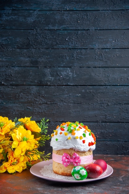 vue de face savoureux gâteau de pâques avec des œufs colorés peints à l'intérieur de la plaque sur fond sombre dessert printemps tarte colorée sucrée ornée de pâques multi