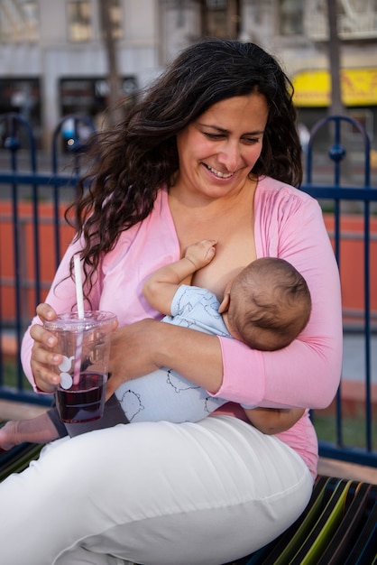 Photo vue de face smiley mère allaitant
