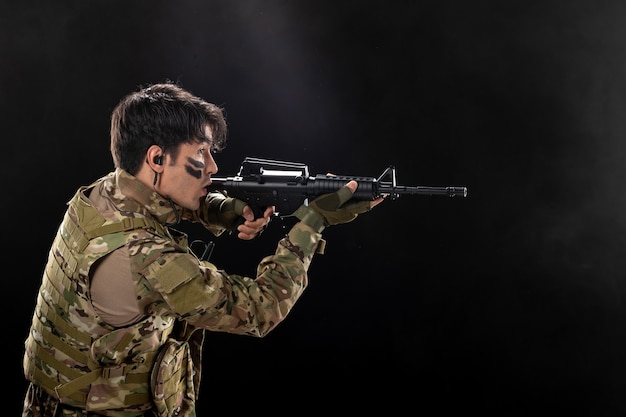 Vue De Face D'un Soldat Masculin Combattant Avec Un Fusil Sur Un Mur Sombre