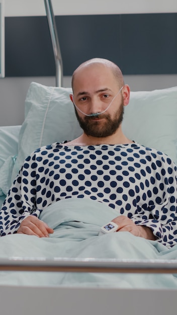 Photo vue de face d'un spécialiste médical afro-américain et d'un homme malade ayant une conférence par vidéoconférence en ligne avec un médecin lors d'une consultation sur la maladie dans une salle d'hôpital