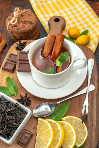 vue de face tasse de thé avec des tranches de chocolat et de citron sur fond sombre cérémonie du petit-déjeuner au cacao couleur des fruits thé sucré