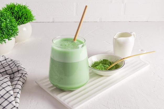 Vue de face d'un verre avec une délicieuse boisson saine Le thé matcha latte bio est une alternative au maximum de nutriments du café du matin