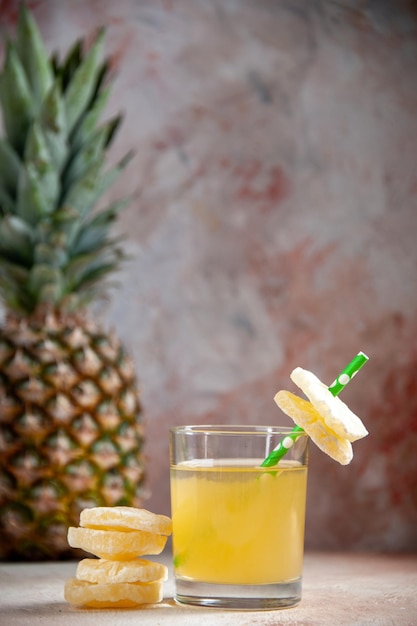 vue de face verre de jus d'ananas frais anneaux d'ananas secs ananas isolé sur fond beige