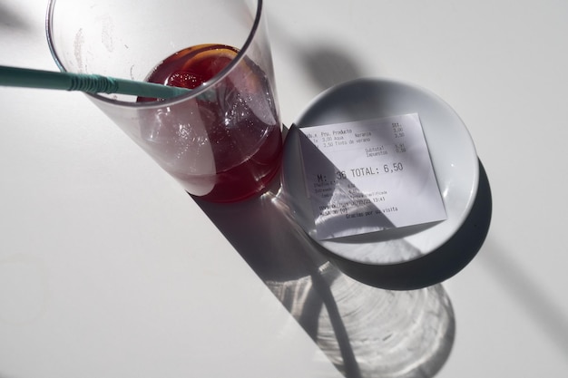 Vue de la facture à payer dans un bar avec un verre sur la table