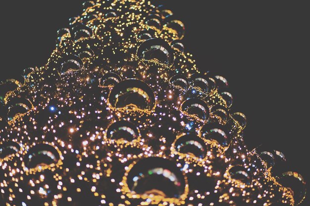 Photo vue à faible angle de l'arbre de noël décoré éclairé contre le ciel la nuit