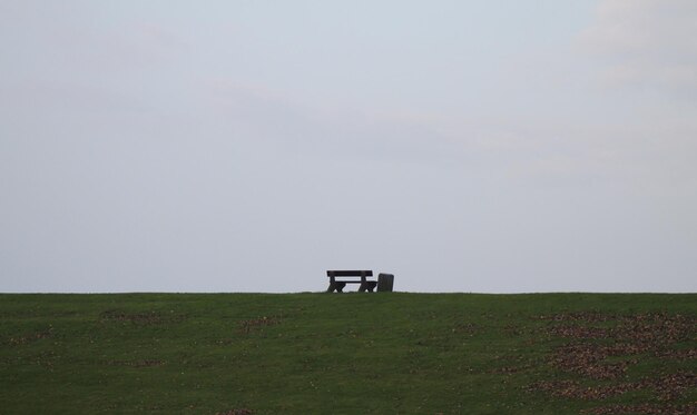 Vue à faible angle du banc sur la colline contre un ciel clair