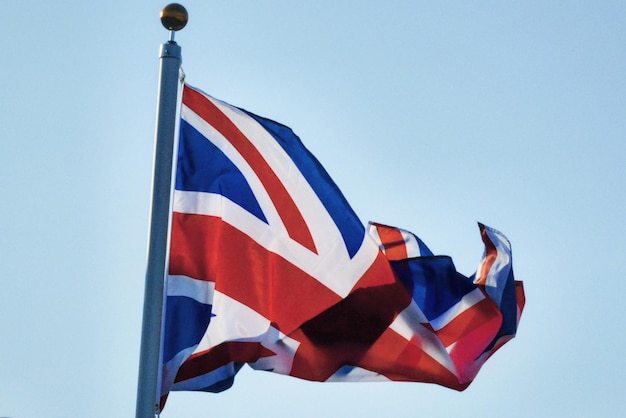 Vue à faible angle du drapeau britannique agitant contre un ciel clair