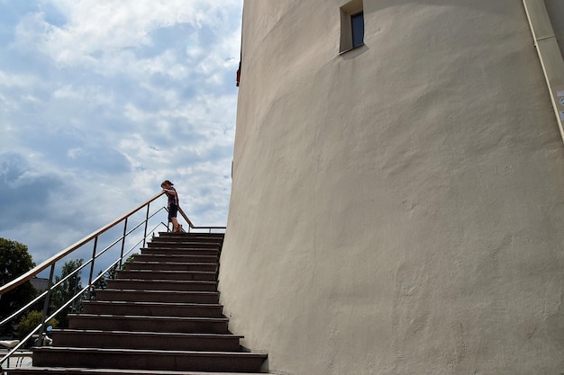 Vue à faible angle du garçon debout sur l'escalier contre le ciel