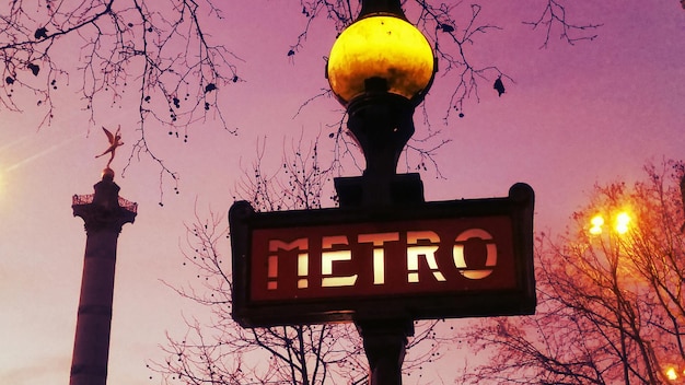 Photo vue à faible angle du poteau de lampe avec du texte contre le ciel au crépuscule