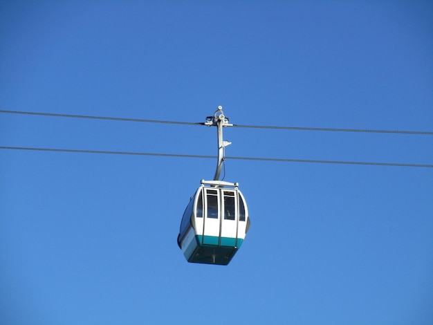 Vue à faible angle du téléphérique aérien contre un ciel bleu clair