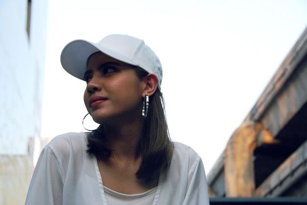 Photo vue à faible angle d'une femme réfléchie portant une casquette contre un ciel clair