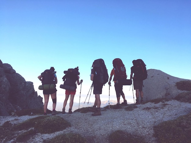 Vue à faible angle des gens debout sur la roche contre le ciel