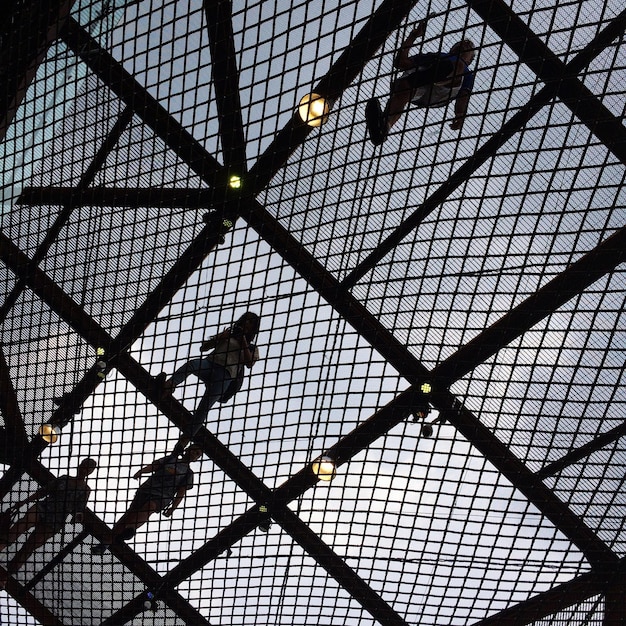 Photo vue à faible angle des gens sur un pont métallique contre le ciel