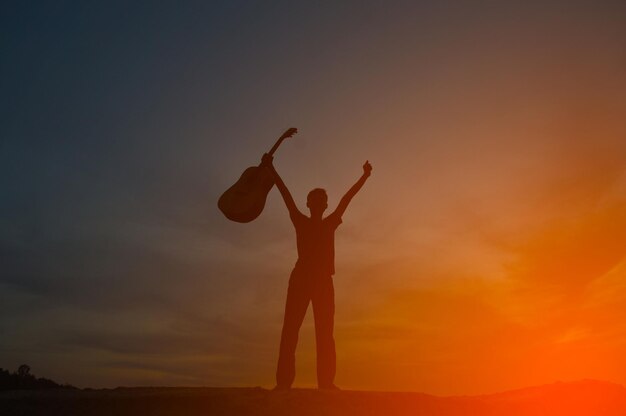 Vue à faible angle de l'homme en silhouette debout contre le ciel au coucher du soleil