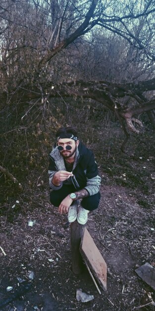 Photo vue à faible angle d'un jeune homme debout contre les arbres