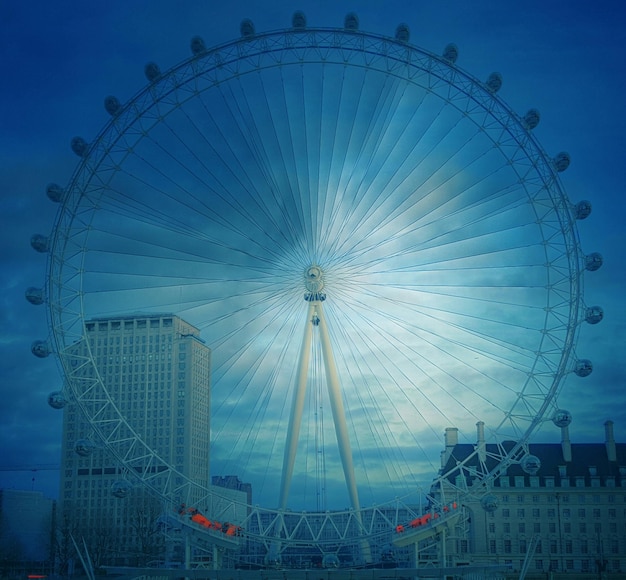 Vue à faible angle de l'œil de Londres contre un ciel nuageux au crépuscule