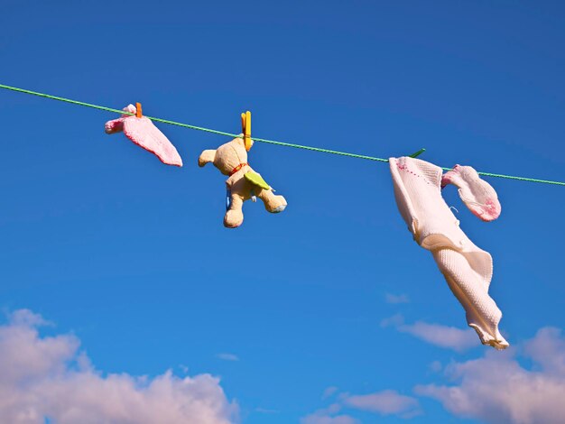 Vue à faible angle des pinces à linge sur une corde contre le ciel bleu