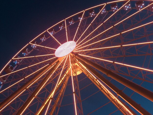 Photo vue à faible angle de la roue de ferris éclairée contre le ciel la nuit