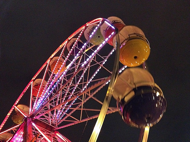 Vue à faible angle de la roue de ferris éclairée contre le ciel