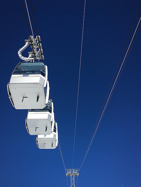 Vue à faible angle des téléphériques aériens contre un ciel bleu clair