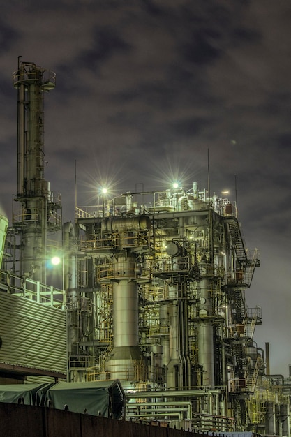 Vue à faible angle de l'usine éclairée contre le ciel la nuit