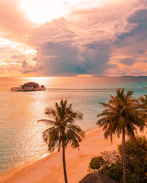 Vue fantastique sur les vagues d'eau de mer calme avec la lumière du soleil orange au coucher du soleil. Antenne de l'île tropicale