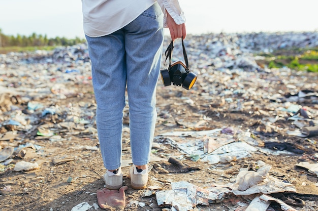 Vue D'une Femme De L'arrière Sur Le Fond De La Décharge Tenant Un Respirateur