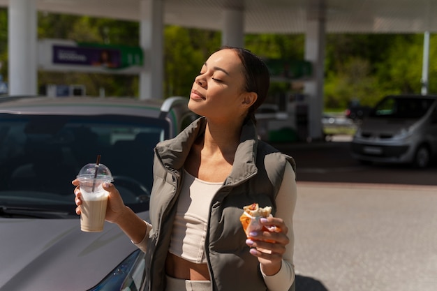 Photo vue de femme avec voiture à la station-service