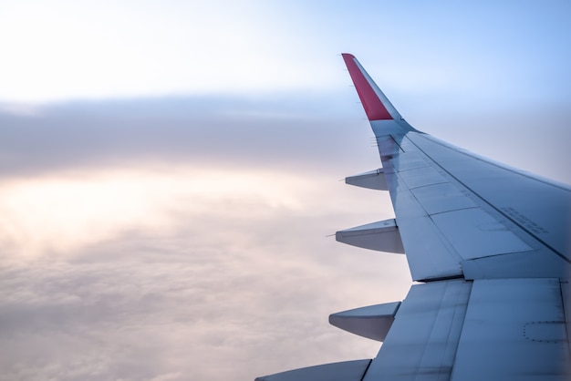 Vue de la fenêtre de l'avion avec aile au lever du soleil.