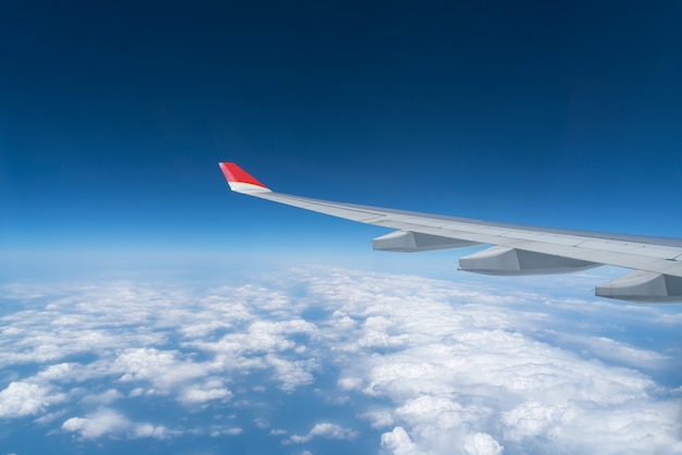 Vue de la fenêtre de l&#39;avion avec ciel bleu et nuages ​​blancs