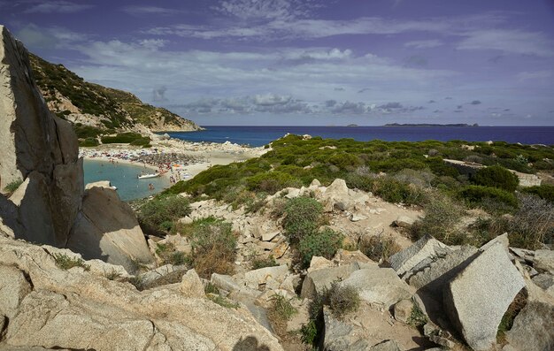 Vue filtrée par les roches calcaires de la plage de Punta Molentis sur la côte sud de la Sardaigne : un coin de paradis.