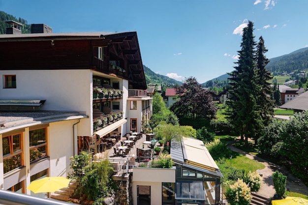 Vue avec fleurs depuis la fenêtre de l'hôtel et station familiale sur le paysage et les installations extérieures en été. Design moderne. Extérieur complexe pour se détendre en vacances. Ciel bleu.