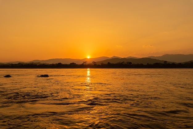 Vue sur le fleuve Mékong du matin entouré de montagnes et de rayons de soleil jaunes au coucher du soleil