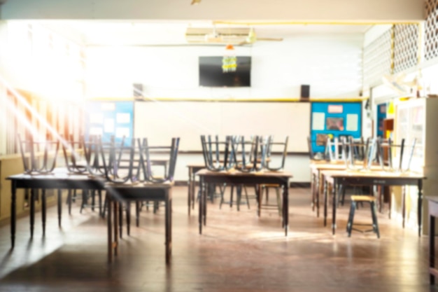 Vue floue de la salle de classe élémentaire sans enfant ni enseignant avec des chaises et des tables sur le campus