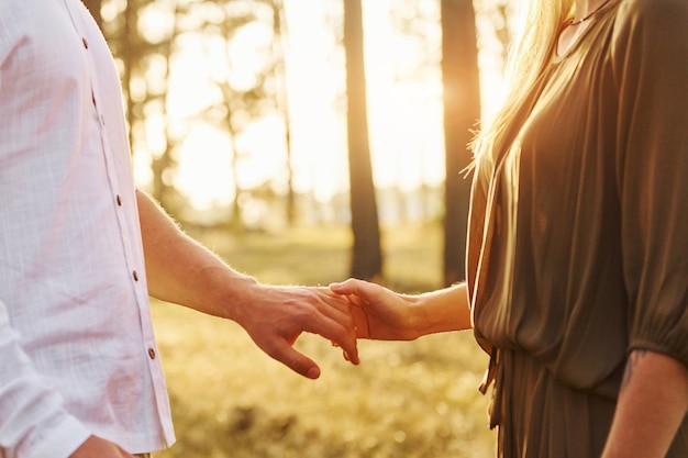 Vue focalisée sur les mains Un couple heureux est à l'extérieur dans la forêt pendant la journée