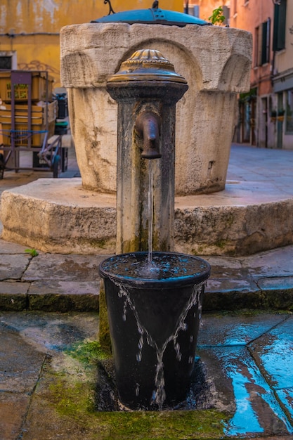 Vue de la fontaine d'eau dans les rues de Venise Italie