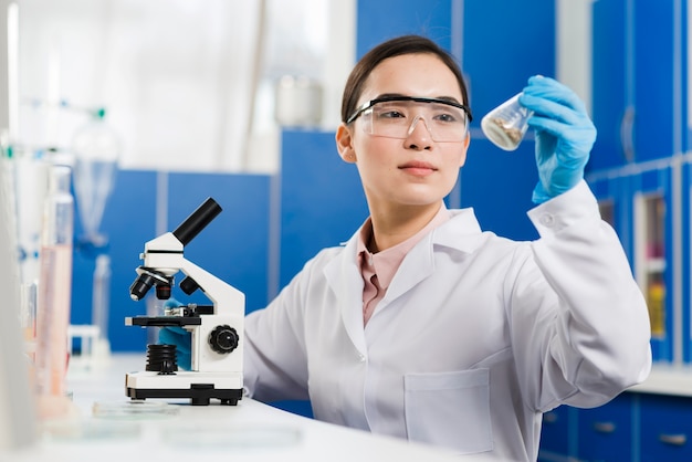 Photo vue frontale, de, femme scientifique, à, microscope