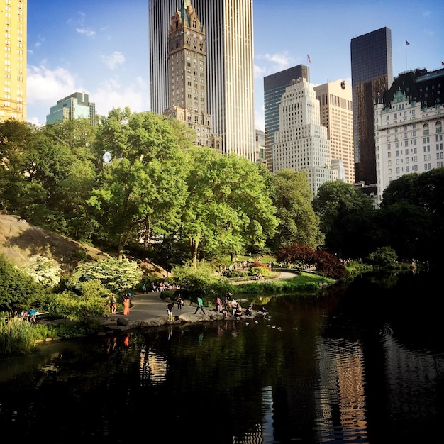 Photo vue des gens dans le parc central avec des gratte-ciel en arrière-plan