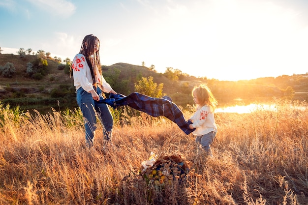 Vue globale de la vie réelle dans le monde entier maman et fille vivantes locales dans des vêtements nationaux et des fleurs