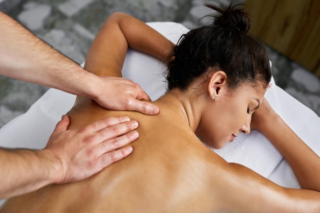 Vue grand angle d'une belle femme recevant un massage du dos au spa